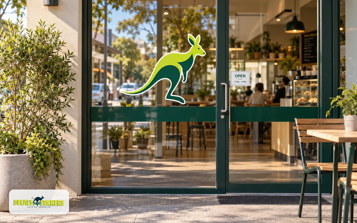 Café glass doors with a large kangaroo logo decal, a small opening hours sticker and a dark green safety band across the glass at waist height