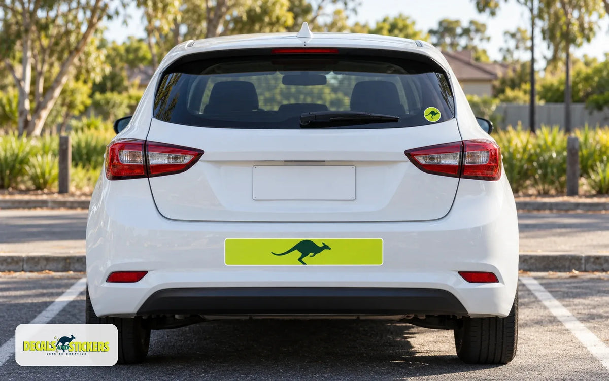 Rear of a white hatchback with a lime green kangaroo bumper sticker and a small round kangaroo sticker in the corner of the rear window